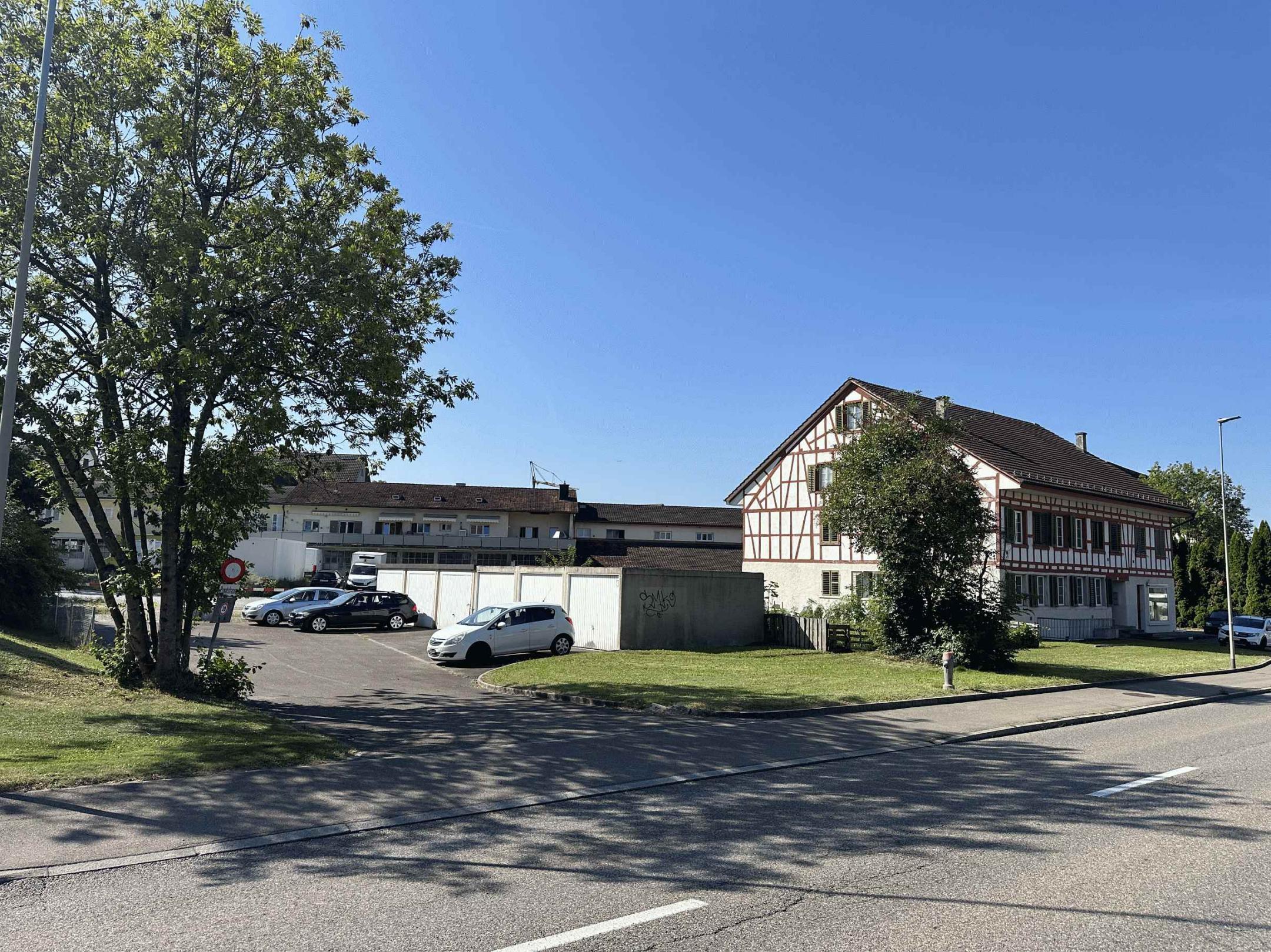 Mehrfamilienhaus mit Garagenboxen und Parkplatz umgeben von Grün an der Wehntalerstrasse in Höri.