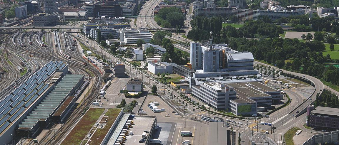 Luftbild von Zürich Herdern stadtauswärts Richtung Limmattal. Links die Auffahrt der Autobahn A1, rechts des Gleisareal mit den Serviceanlagen der SBB. Zwischen den Verkehrsachsen das Rechenzentrum der Swisscom.