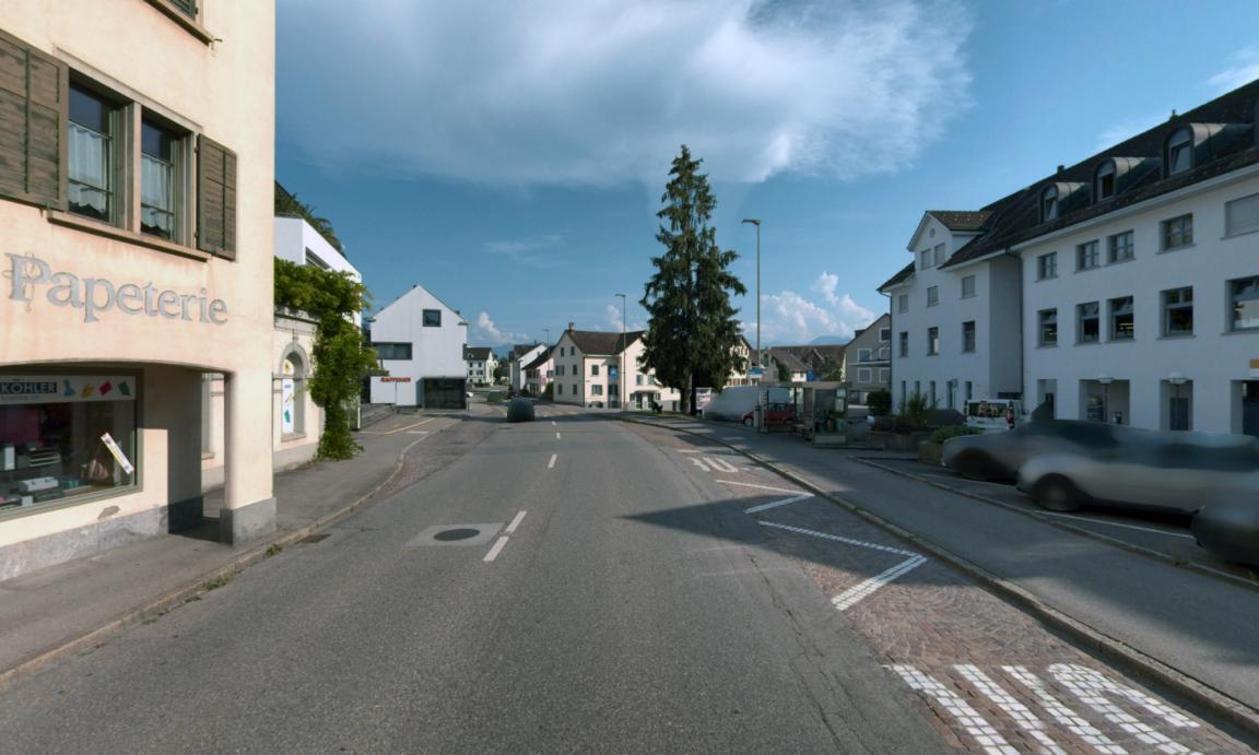 Strasse durch Häuser mit einer Bushaltestelle.