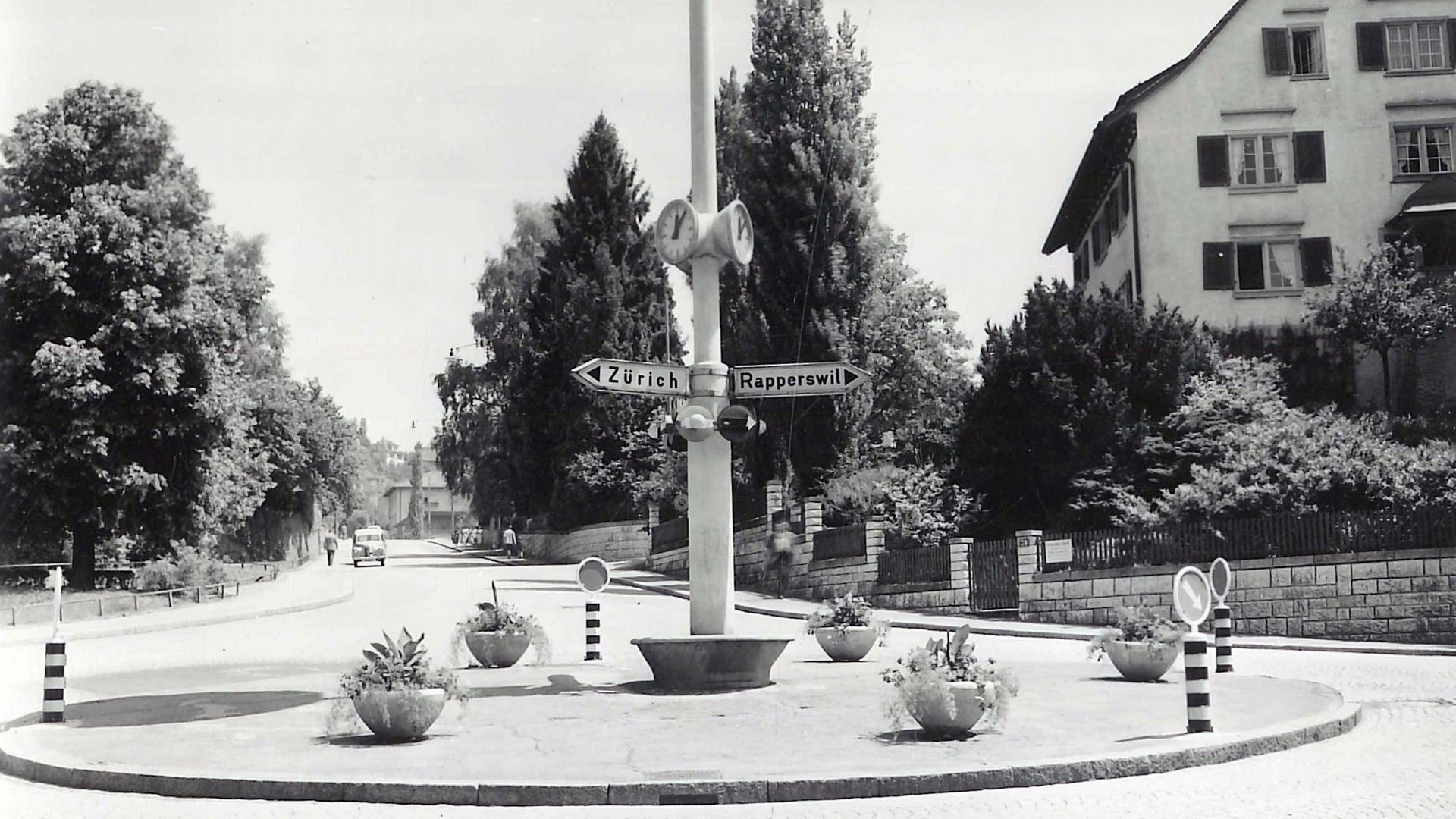 Schwarz-Weiss-Aufnahme des Dufourkreisels mit zentralem Wegweiser und Blumenkübeln.