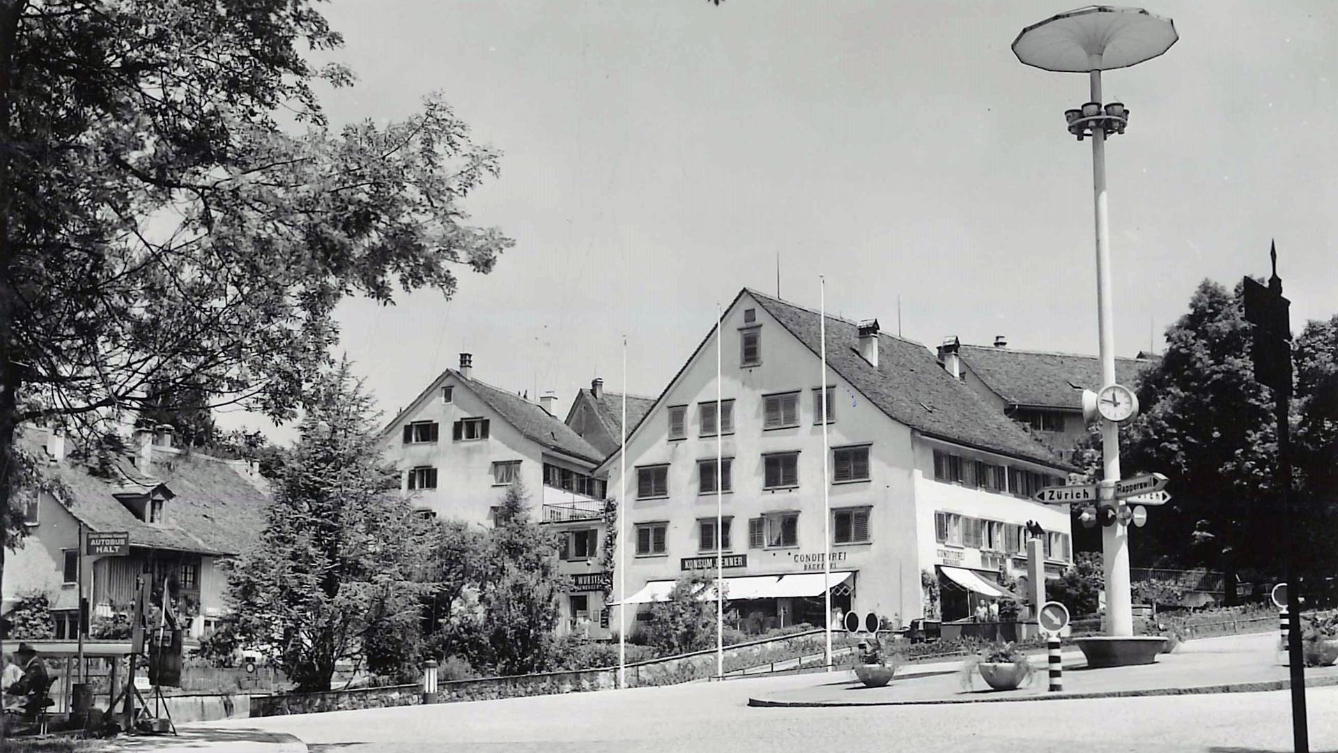Historische Schwarz-Weiss-Aufnahme von 1957, die den Dufourkreisel, die zentrale Beleuchtungssäule und die umliegenden Geschäftshäuser zeigt.