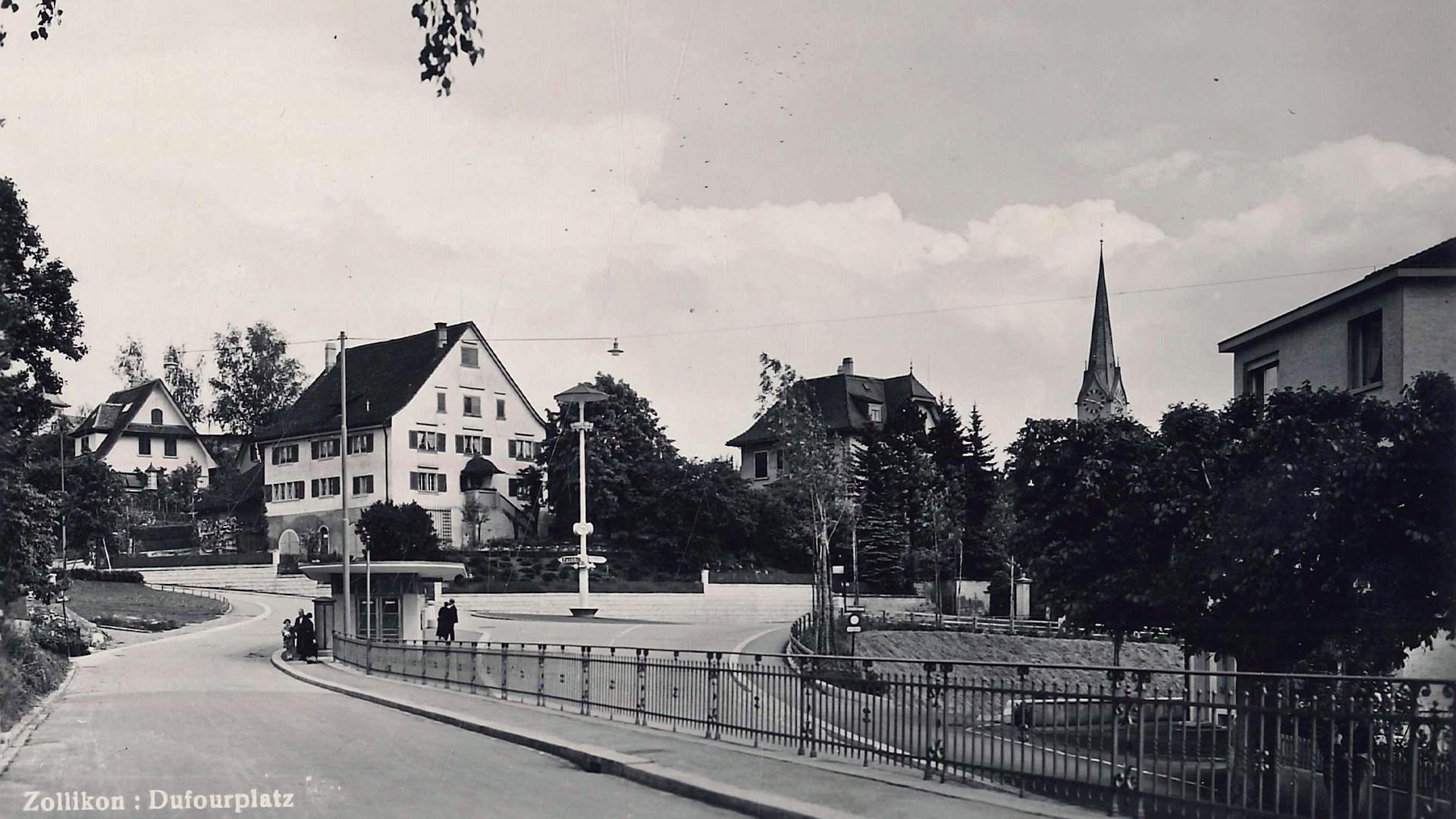Historische Schwarz-Weiss-Aufnahme des Dufourplatzes mit der Kirche im Hintergrund und einer Bushaltestelle.