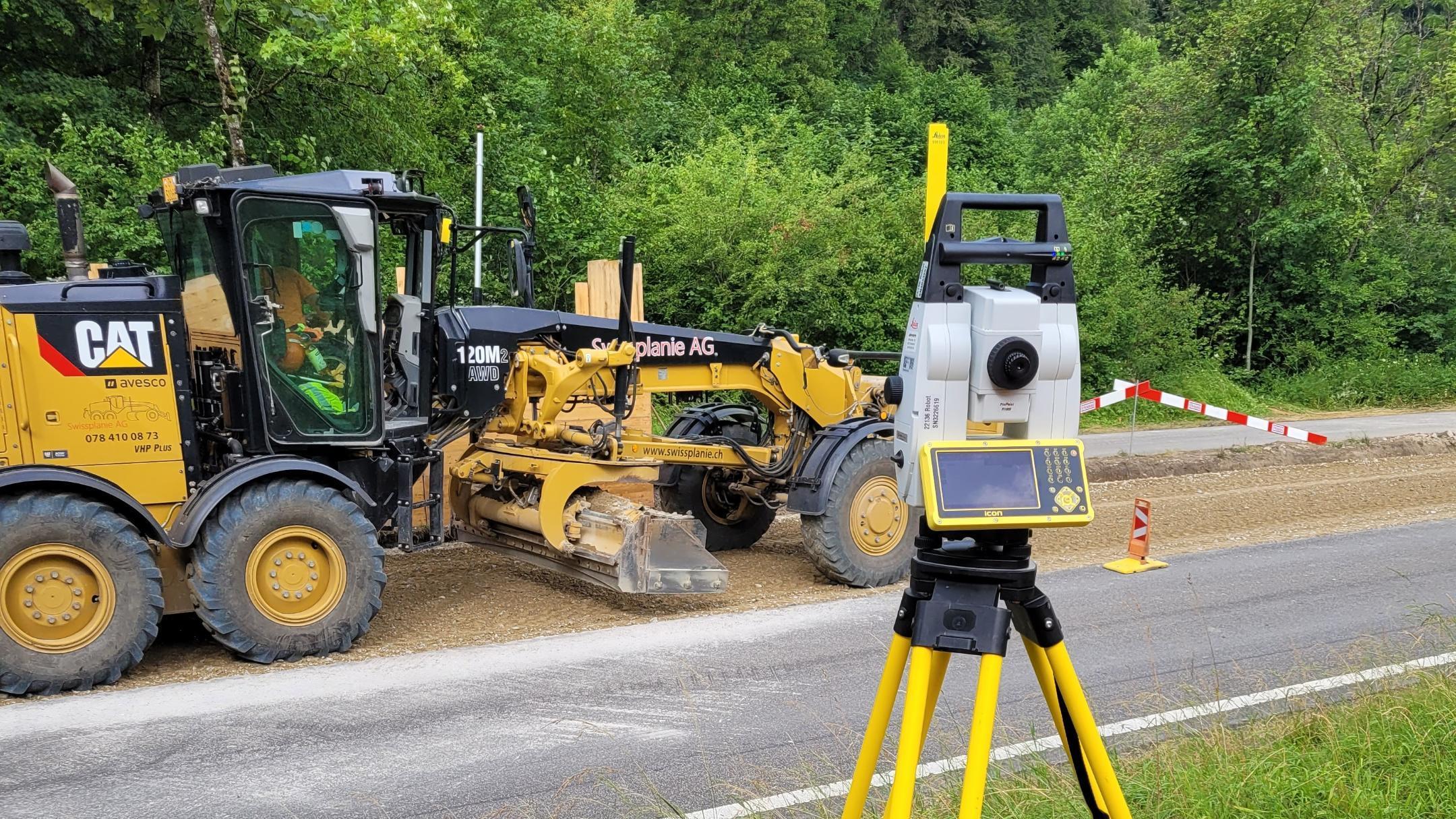 Einbau der Planie erfolgt mithilfe eines Graders, einem schweren Baufahrzeug, und der Anwendung eines Local Positioning Systems (LPS) zur genauen Höhenkontrolle. 