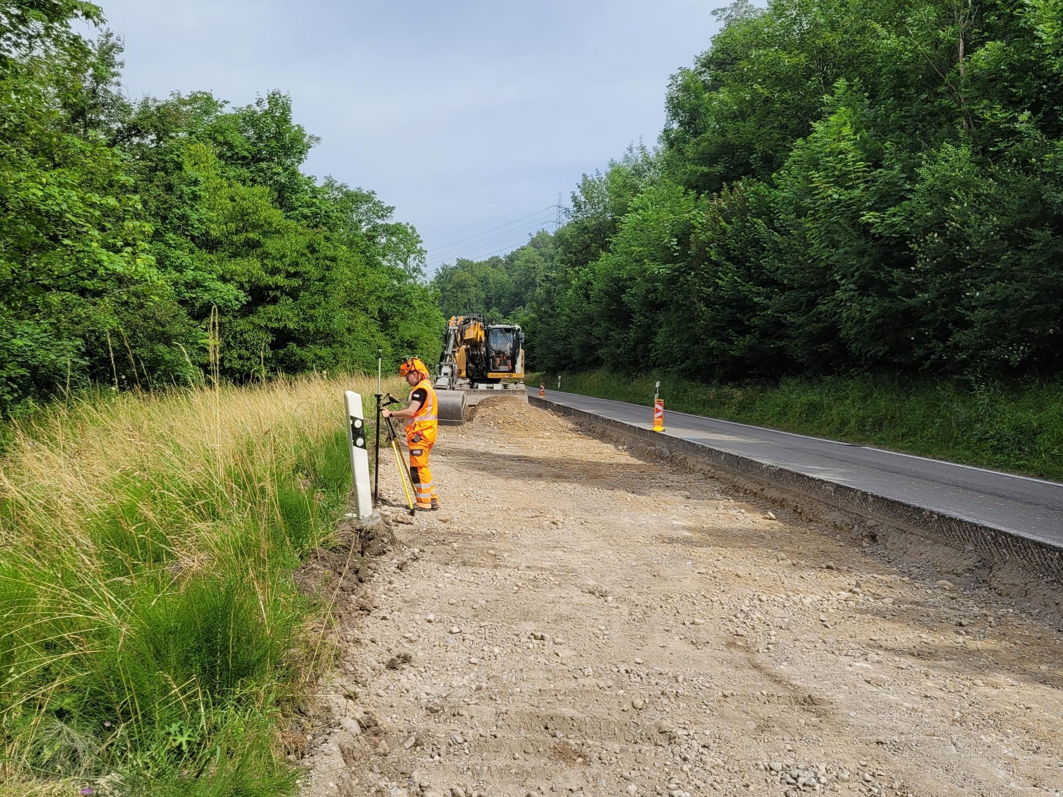 Die BIM-Managerin verwendet Vermessungsgeräte, um die Höhe der eingebauten Planie zu messen. 