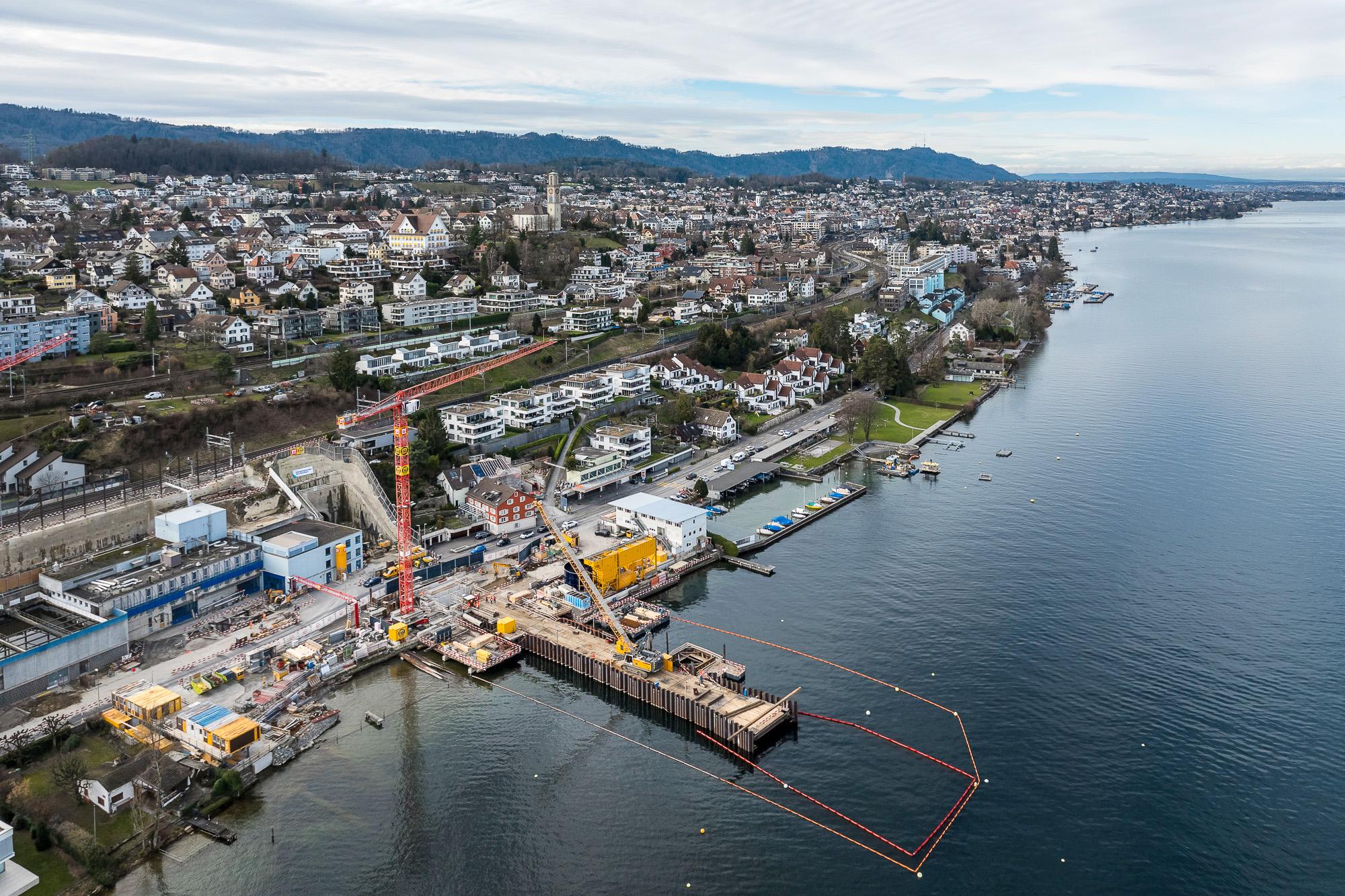 Luftaufnahme des Zürichseeufers in Thalwil. Rechts ist der See, auf der linken Seite befindet sich das Ufer mit einer grossen Baustelle.