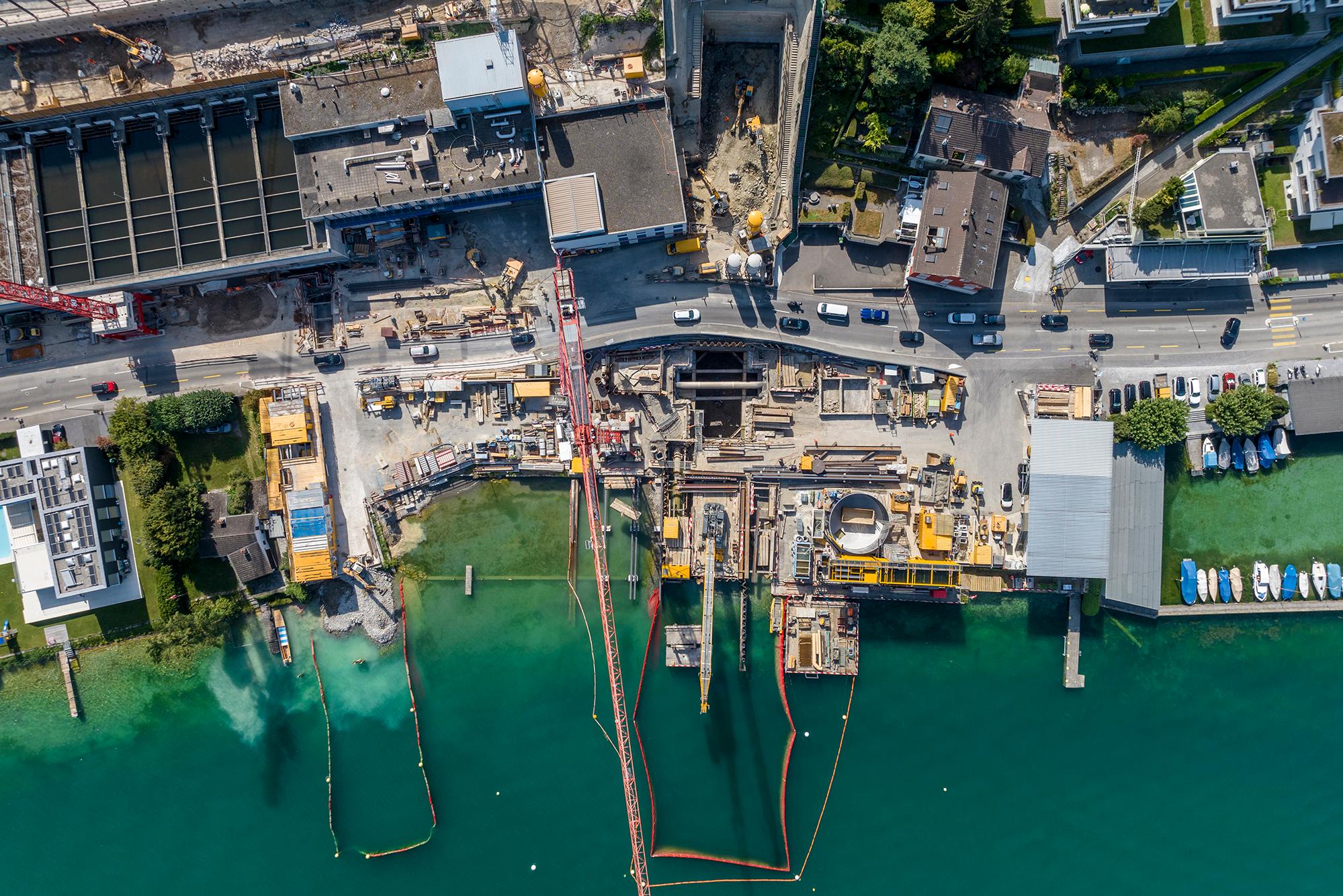 Luftaufnahme des Zürichseeufers in Thalwil. Im unteren Teil des Bildes ist der See zu sehen, eine Baustelle nimmt die obere Hälfte des Bildes ein.