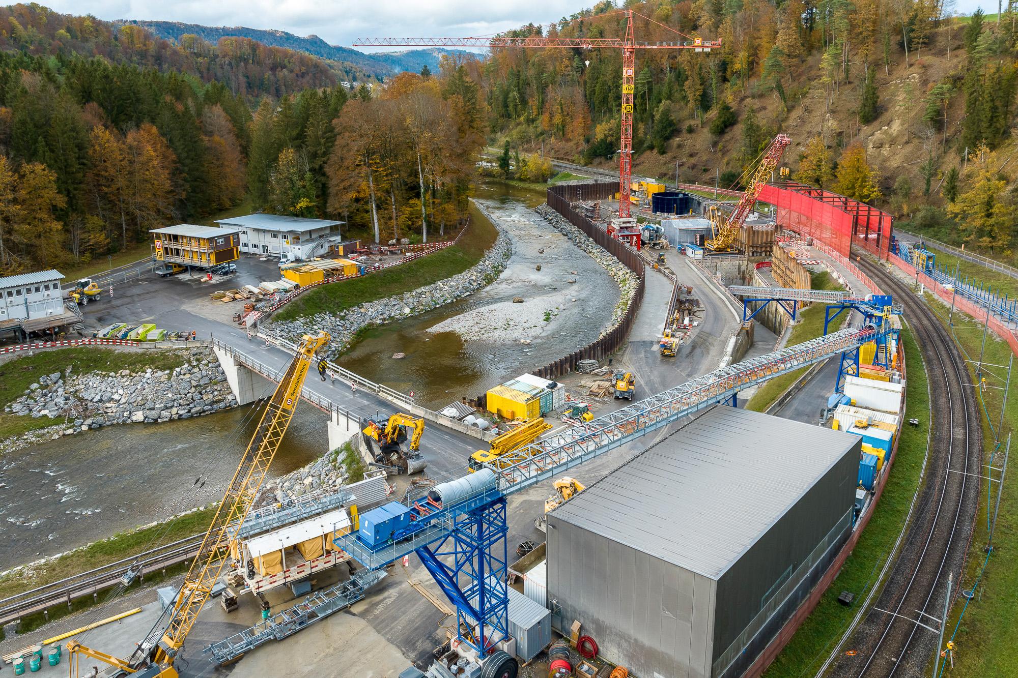 Eine grosse Baustelle befindet sich am Sihlufer mit einigen Bürogebäuden, einem Raupenkran, einem Förderband und einem weiteren Baustellengebäude