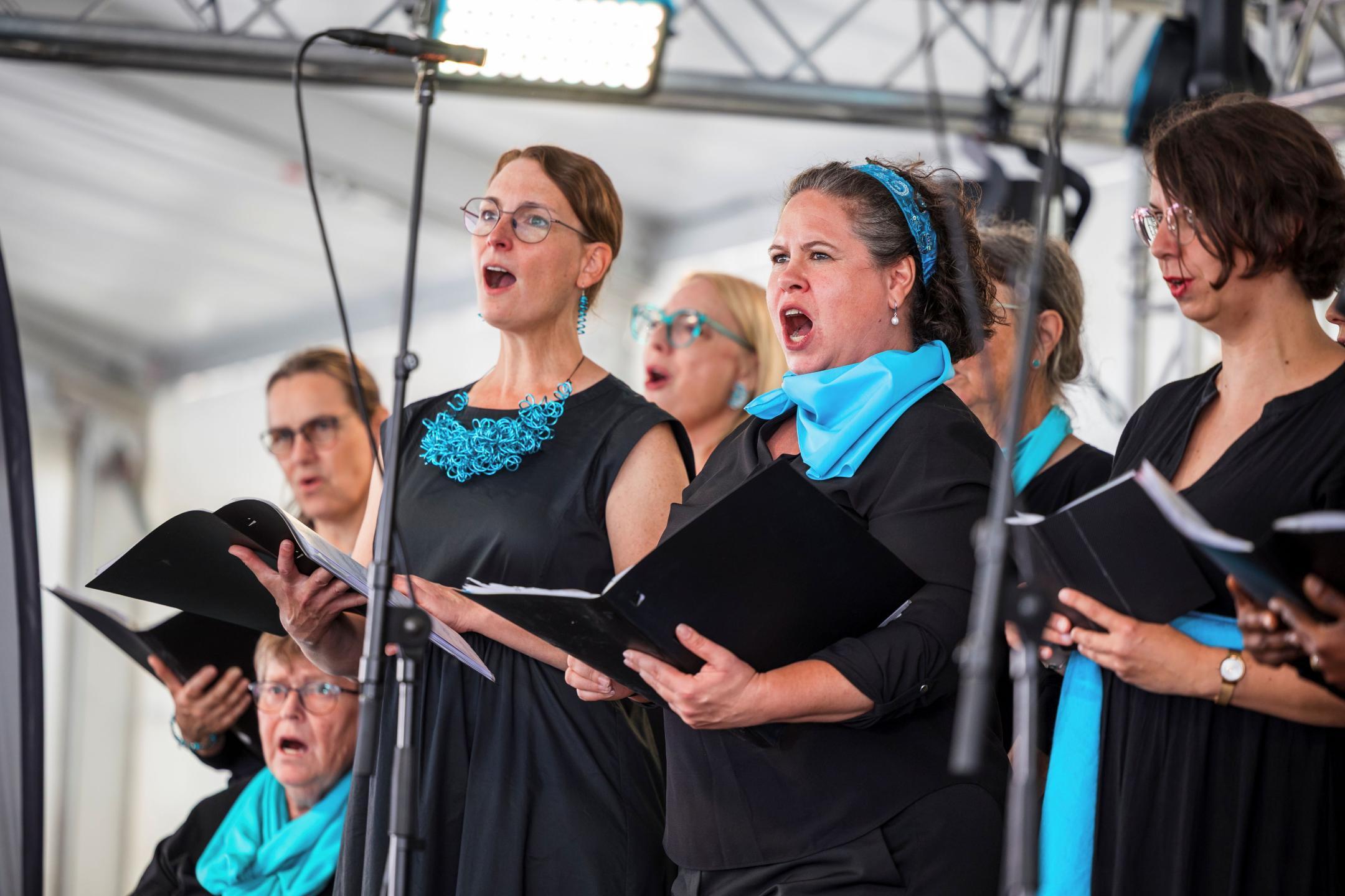 Frauen mit Liedermappen am Singen