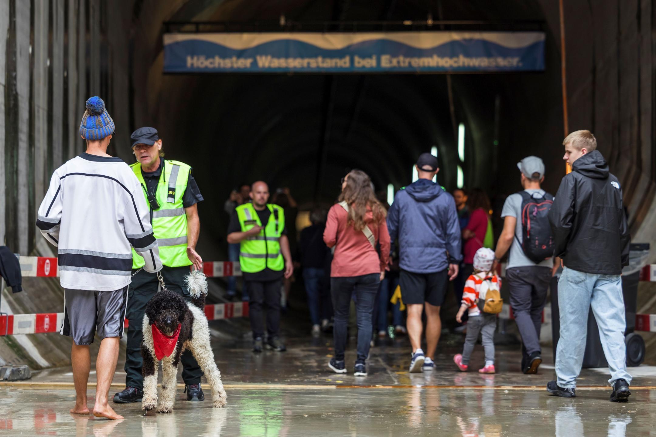 Sicherheitsbeamte mit Leuchtwesten vor dem Stolleneingang mit den loslaufenden Stollenwandernden.