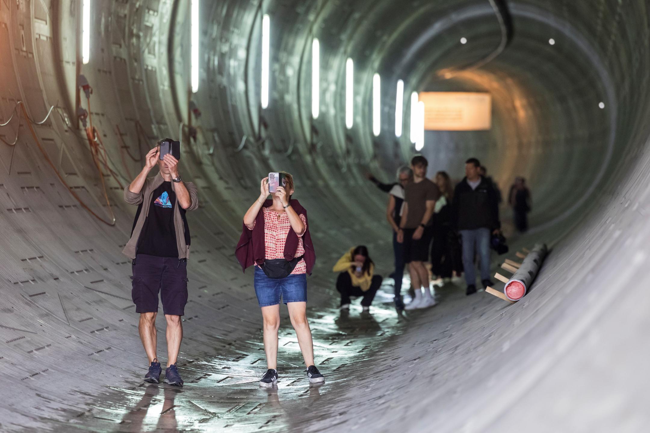 Stollenwandernde im Stollen, die teilweise mit ihren Handys Fotos schiessen.