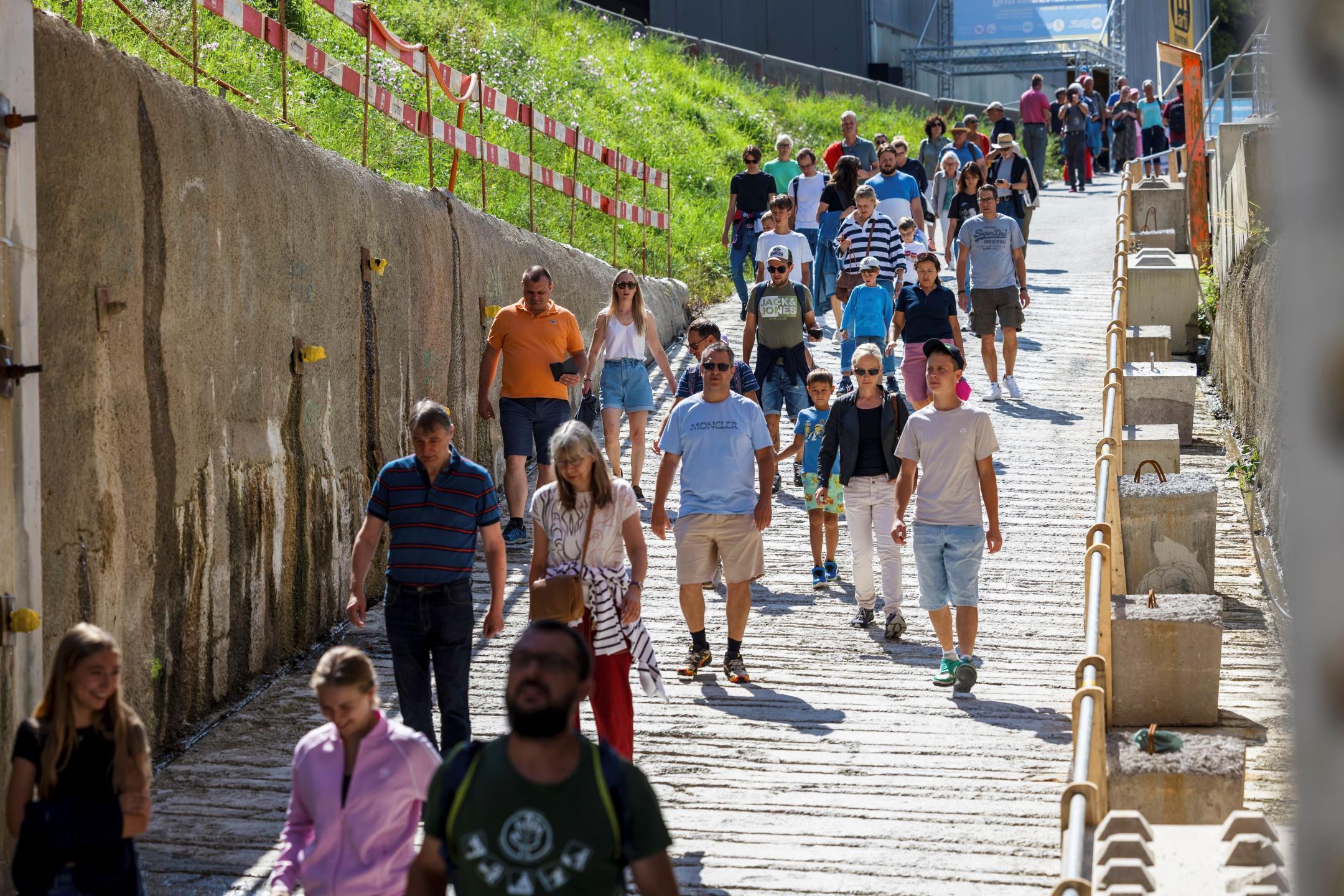 Die Leute wandern auf den Stolleneingang zu.