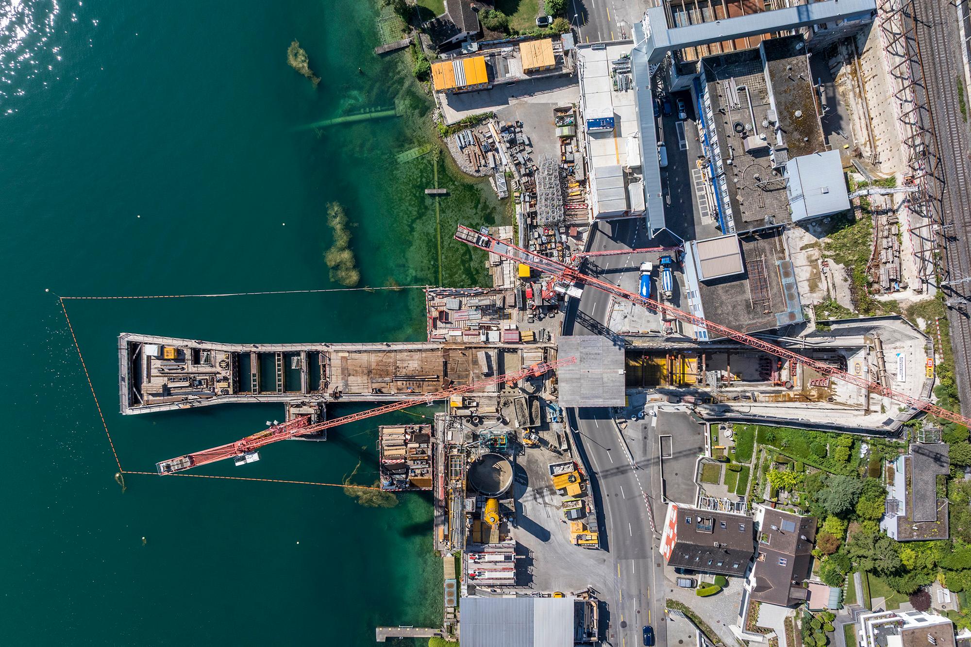 Drohnenaufnahme der Baustelle in Thalwil mit links dem See, rechts dem Hang und in der Mitte dem Auslaufkanal