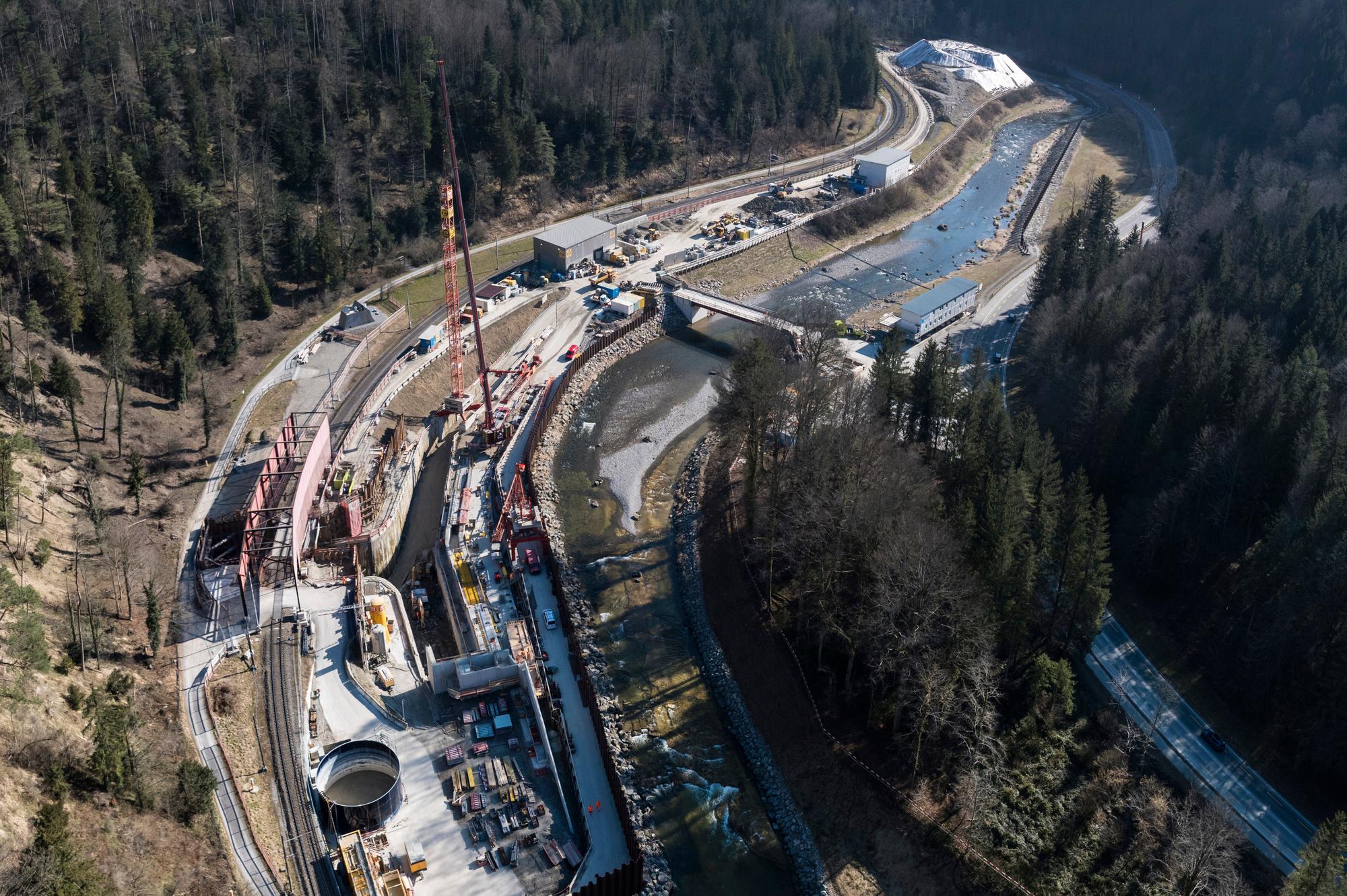 Drohnenaufnahme der Baustelle im Sihltal. In der Mitte die Sihl, rechts Wald, links die Baustelle mit Baumaschinen und die Schienen der SZU.