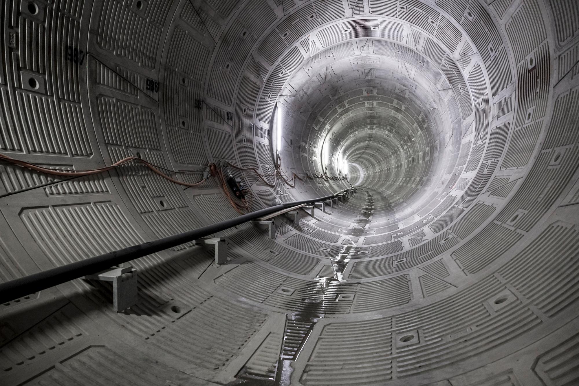 Entlastungstollen von Innen mit Tunnelwänden und einer nach links verlaufenden Kurfe des Tunnelverlaufs.