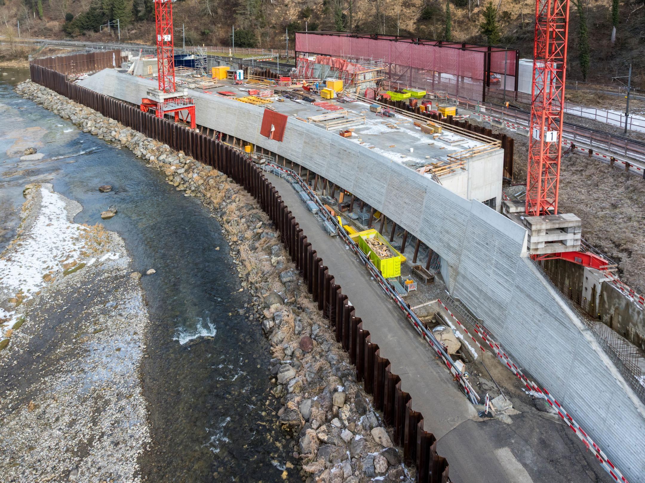 Betonbau des Einlaufbauwerks und des Betriebsgebäudes neben der Sihl mit je zwei Baukränen.