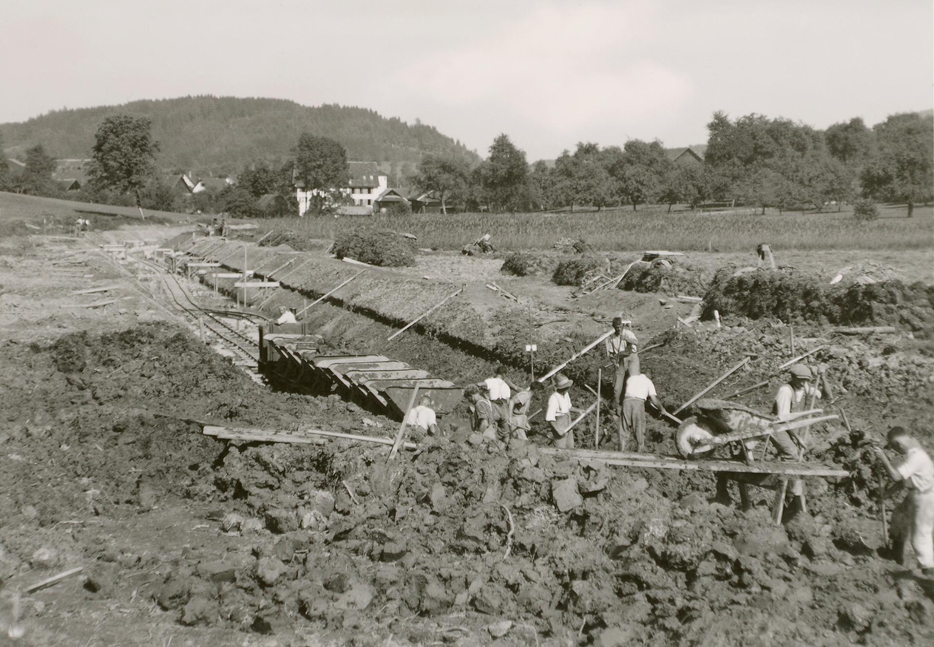 Die alte schwarz-weiss Aufnahme zeigt Männer bei der Arbeit am Flussbett.