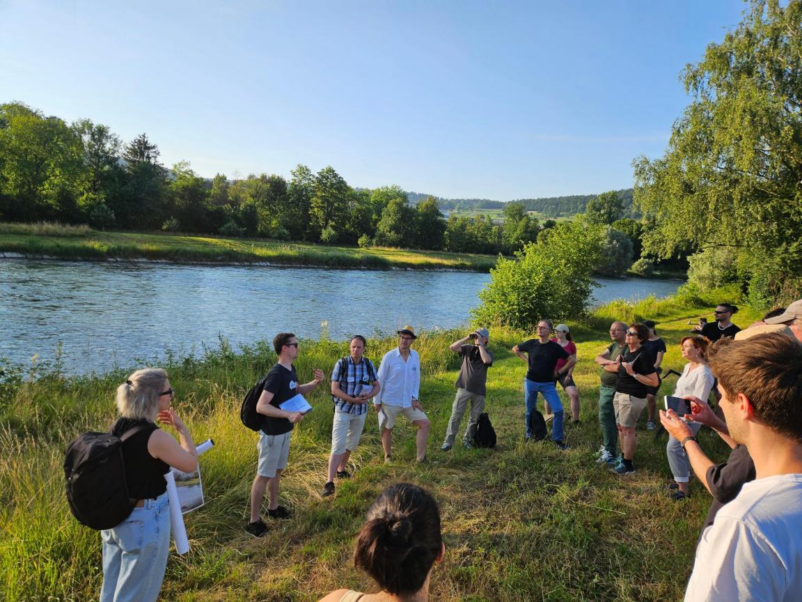 Am Ufer der Limmat stehen gut ein Dutzend Personen und hören einer Fachperson bei den Ausführungen zum Projekt Lebendige Limmat zu.