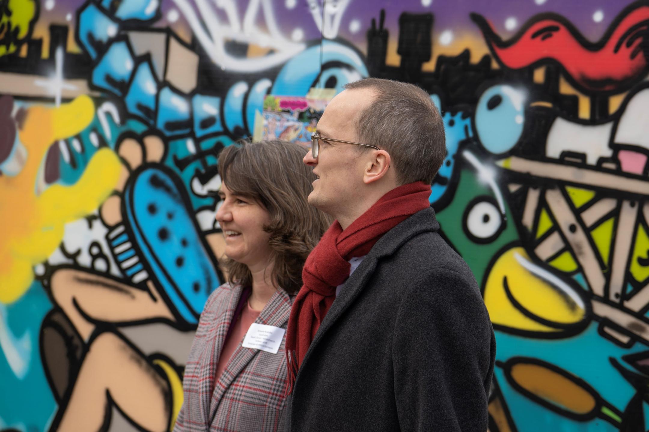 Simone Brander und Martin Neukom vor buntem Graffito.