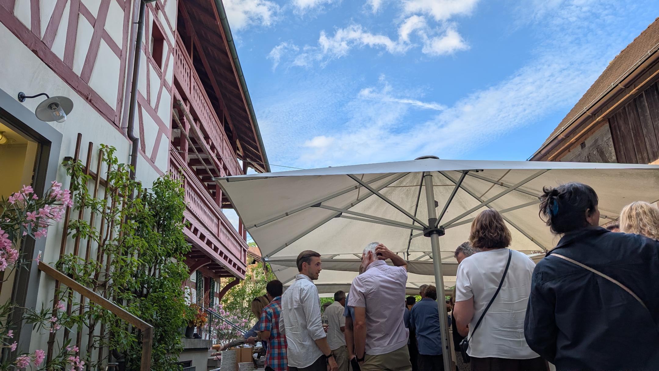 Blick auf einen Hof mit einer Gruppe Menschen unter blauem Himmel