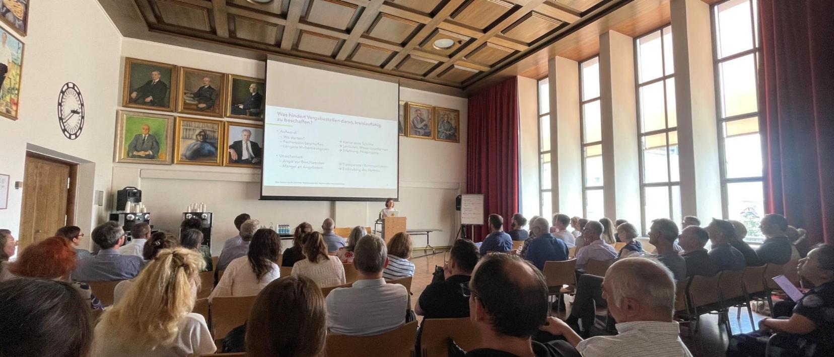 Teilnehmer hören einem Vortrag über Beschaffungsrecht und Kreilaufwirtschaft zu.