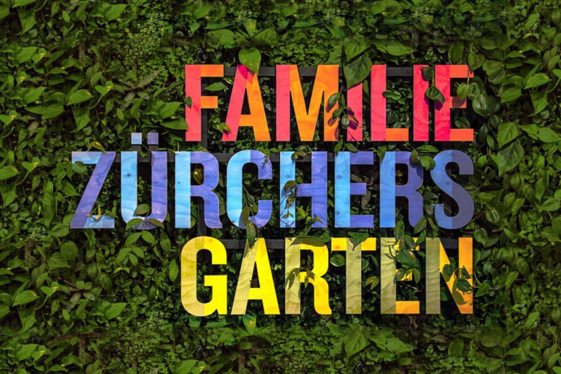 Das Logo «Familie Zürchers Garten» hängt an einer Hecke.