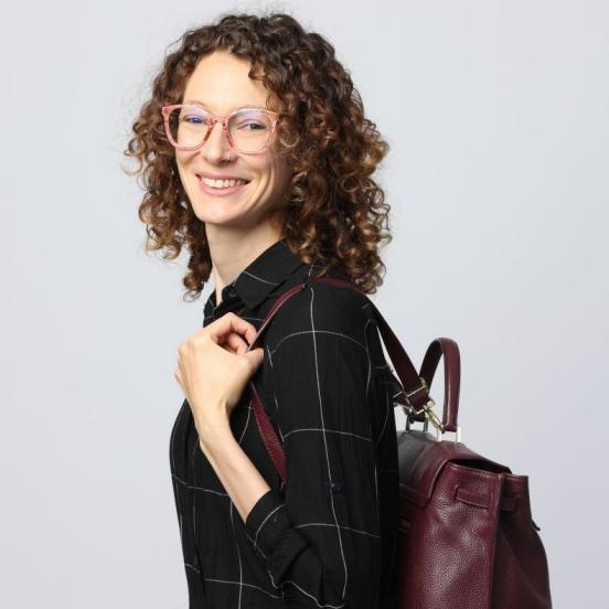 Frau mit braunen gelockten Haaren und einer Brille