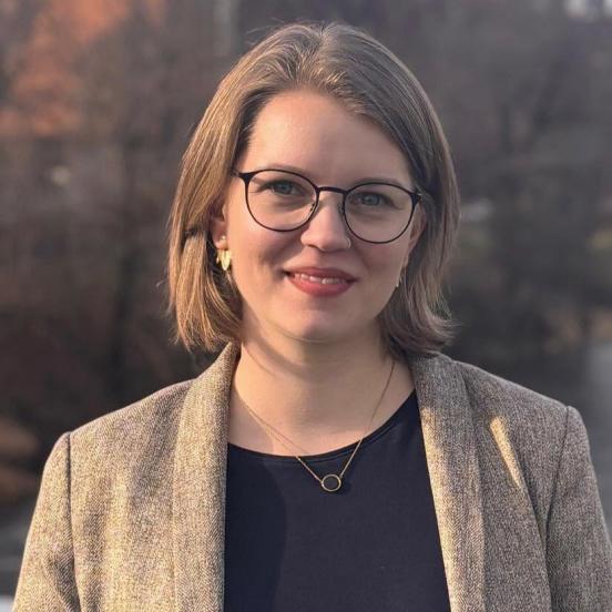 Portraitbild einer Frau mit schulterlangen braunen Haaren und einer Brille
