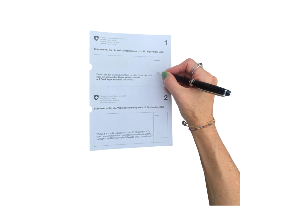 Eine Frauenhand scheribt mit einem Stift etwas in das Feld auf dem Stimmzettel. 