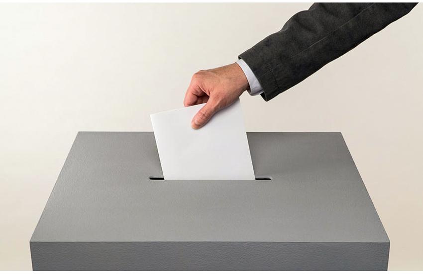 Bild Die Wahl-Zettel in die Urne werfen.