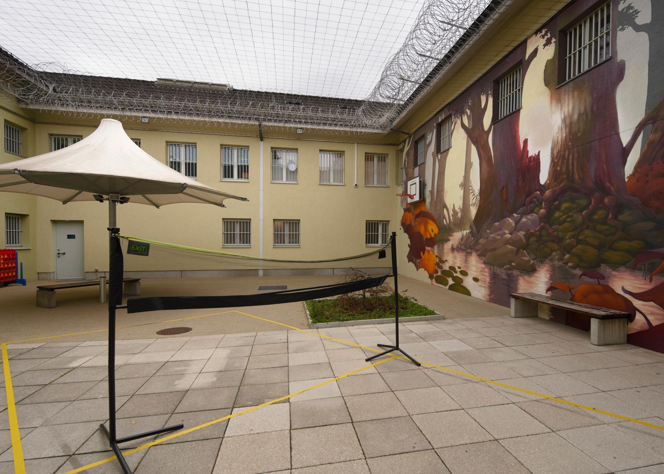 Umzäunter Hof mit Volleyballnetz