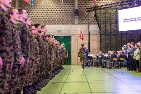 Entlassungsformation in Achtungsstellung beim Fahnenmarsch und der vorbeilaufenden Schweizerfahne mit Fähnrich