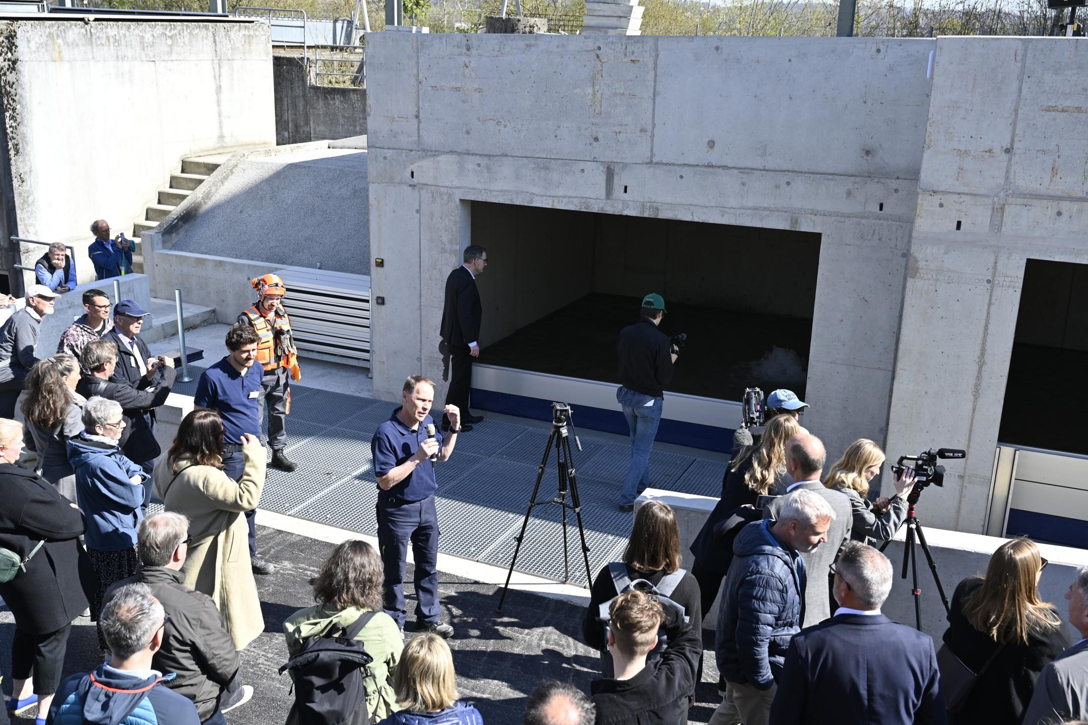 Ein Fachmann der Gebäudeversicherung Zürich (GVZ) erklärt an einer Live-Demo den Nutzen der Anlage. Um ihn herum stehen zahlreiche interessierte Personen.