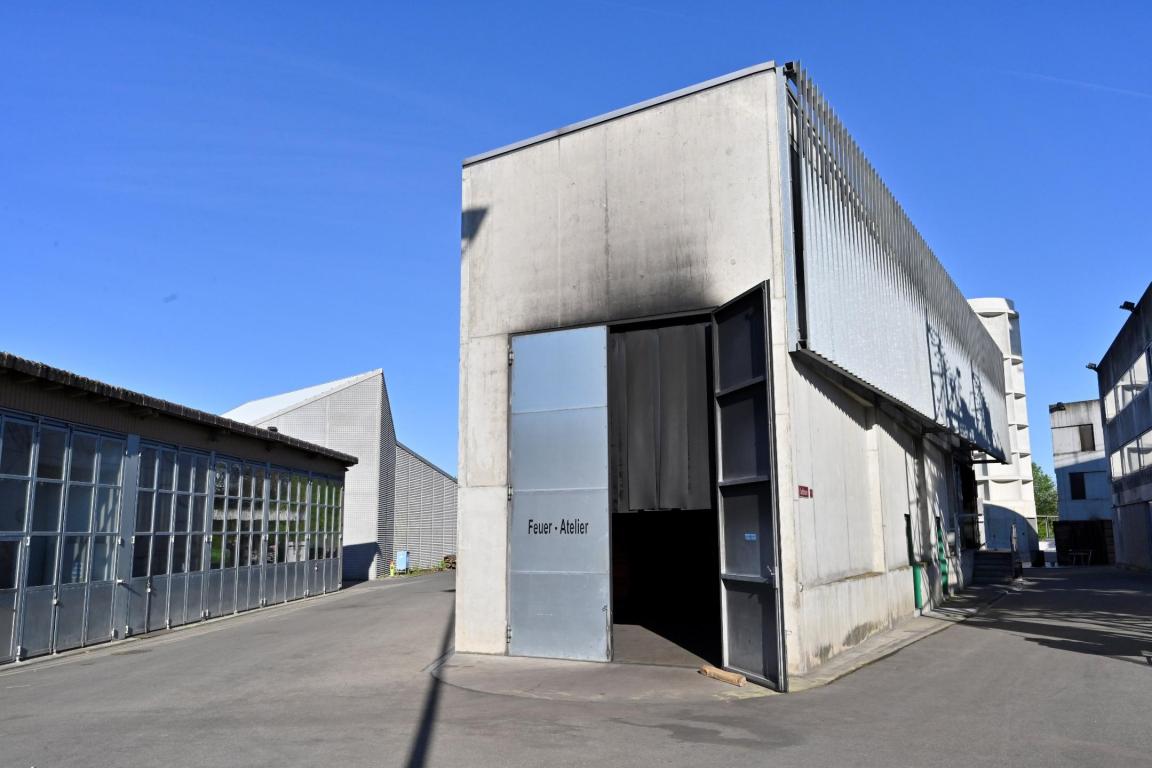 Ein hohes Betongebäude mit einer grossen Metalltür, welche leicht geöffnet ist.