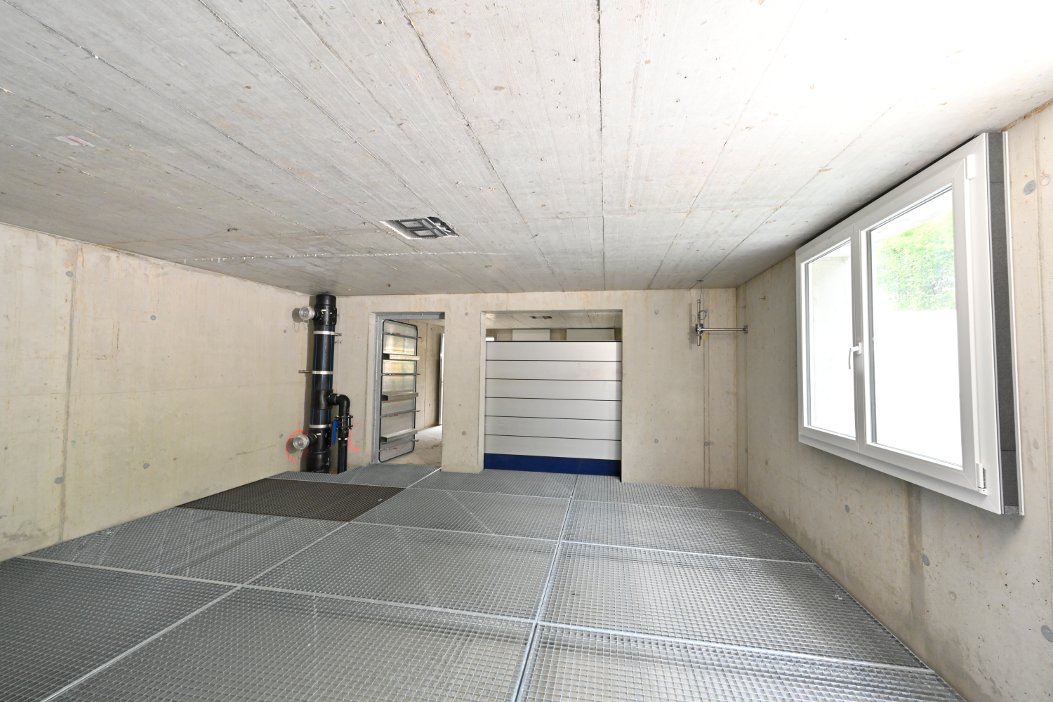 Ein heller Raum in der Anlage mit einem Fenster und einem Gitterboden.