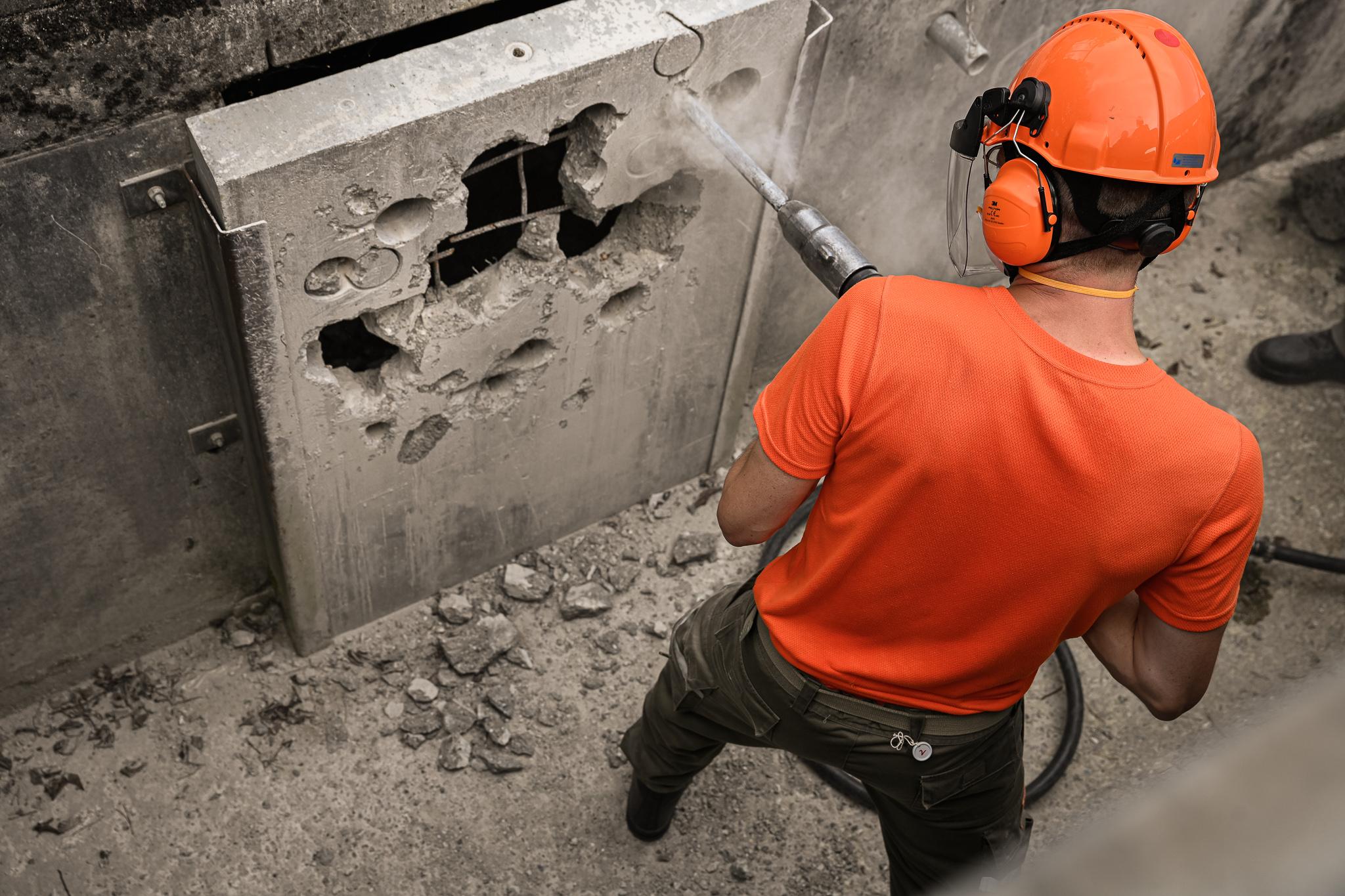 Auf einer sogenannten Trümmerpiste ist ein Zivilschützer am Werk. Er ist ausgerüstet mit starkem Gerät.