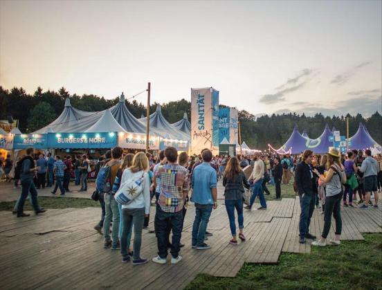 Besucher eines Openairs stehen auf Bodenschutzmatten.