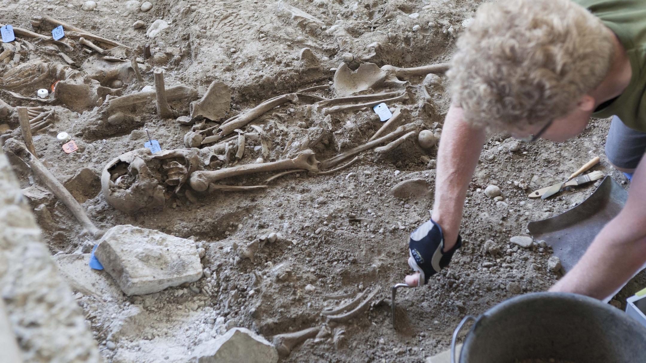 Ein Archäologe legt bei einer Grabung unter der Kantonsschule Küsnacht menschliche Skelette frei.