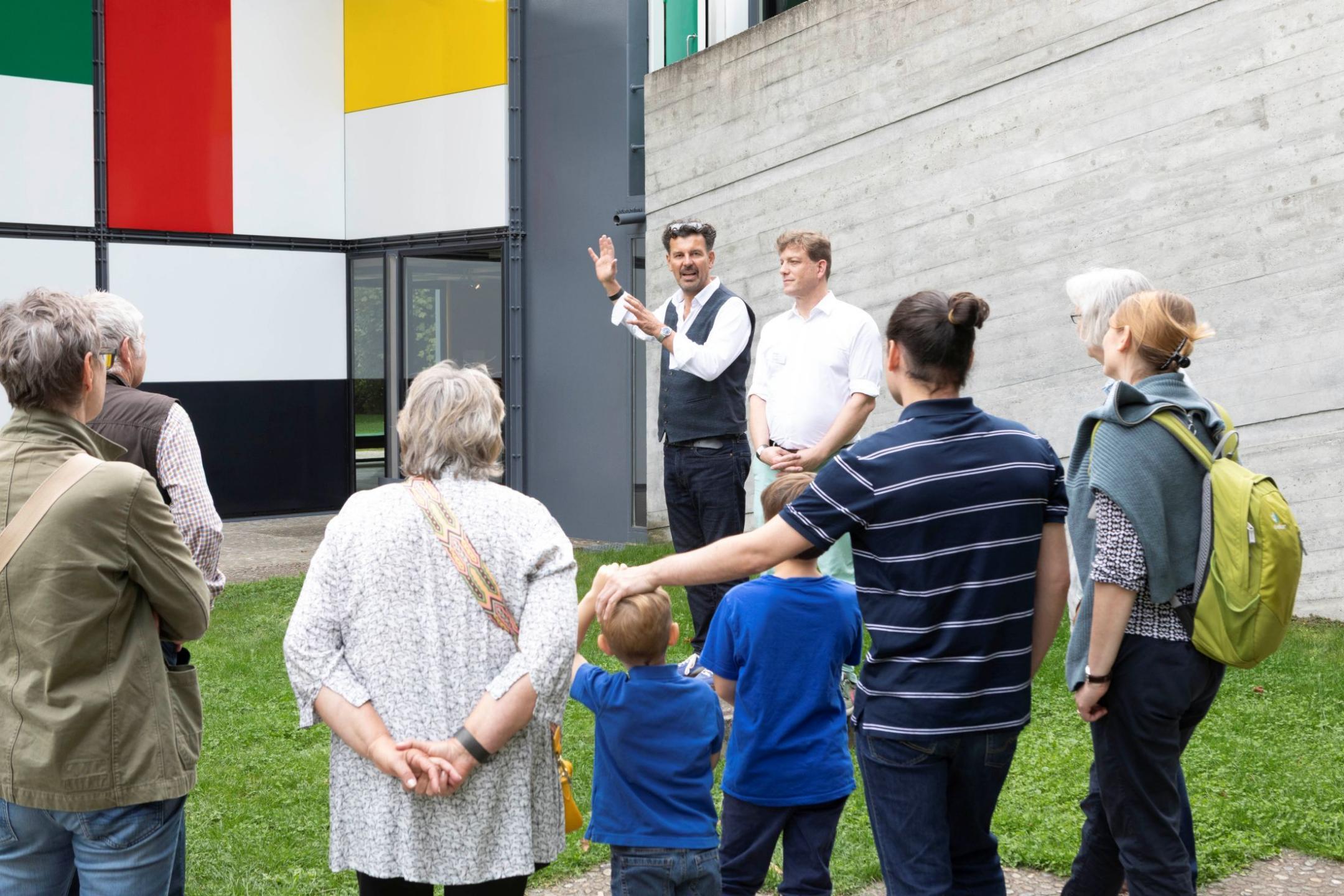 Gross und Klein lauschen den Ausführungen von Lukas und Pietro vor dem Pavillon Le Corbusier
