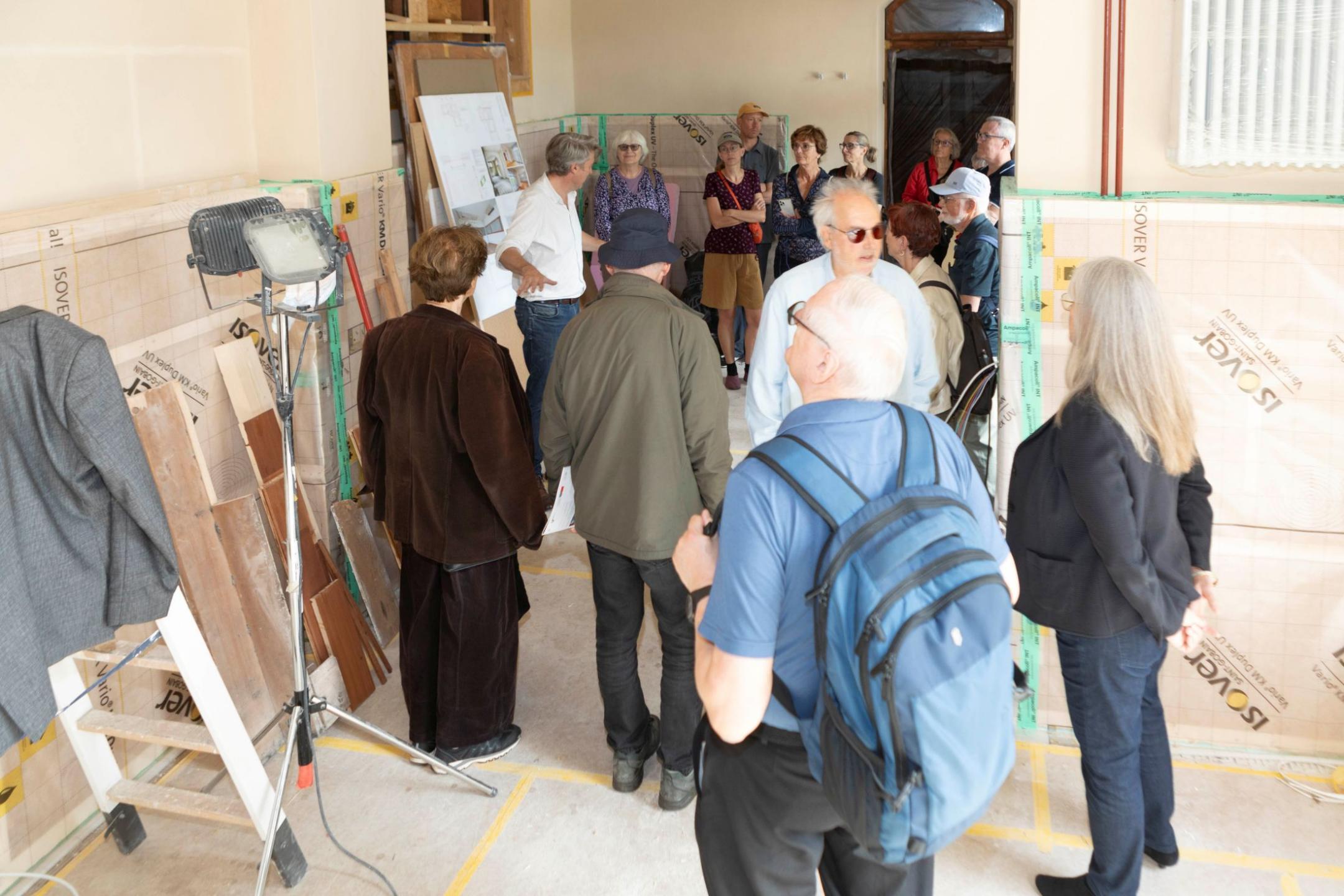 Eine Gruppe von Menschen auf der Baustelle im Kutscherhaus der Villa Patumbah.
