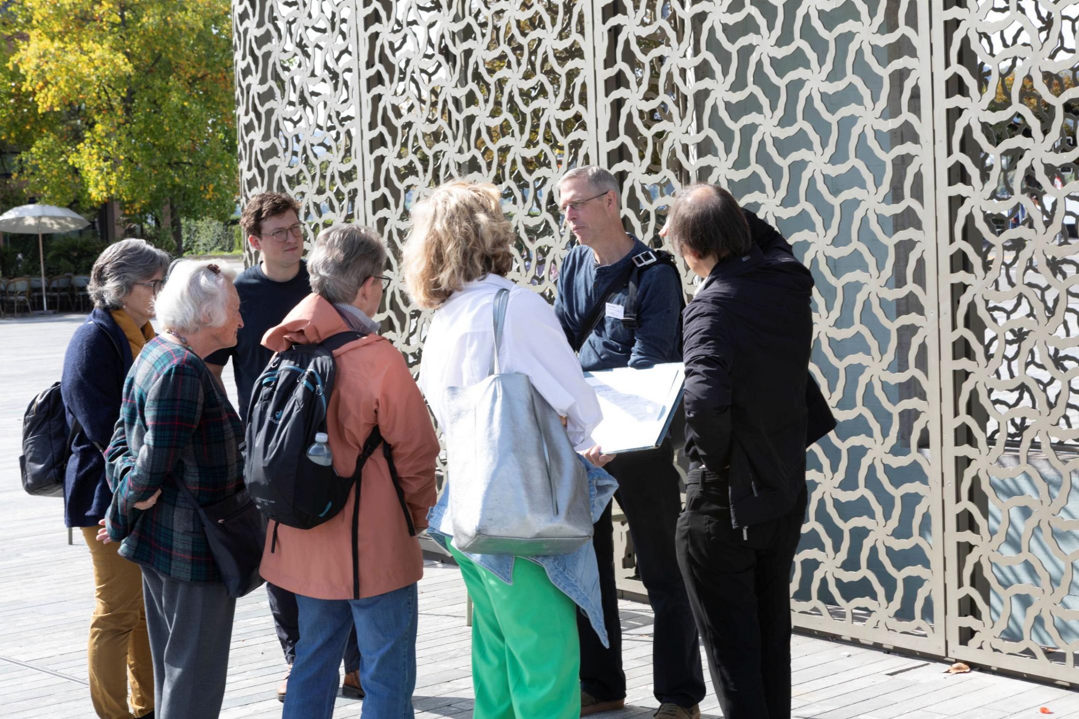 Eine gruppe von Menschen lauscht auf dem Sechseläutenplatz den Ausführungen eines Archäologen.