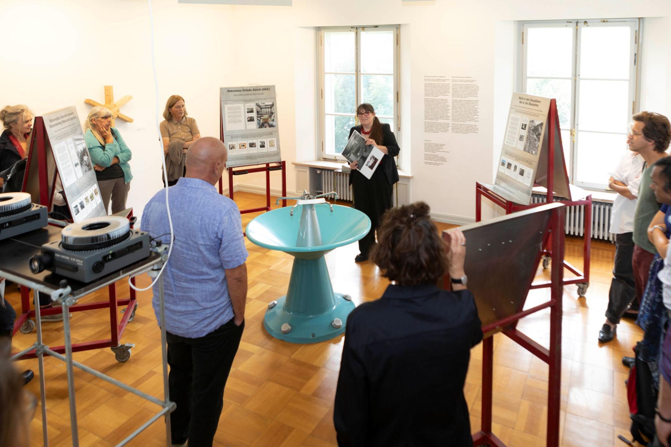 Ein Ausstellungsraum im ZAZ Bellerive mit verschiedenen Personen, die an einer Führung teilnehmen.