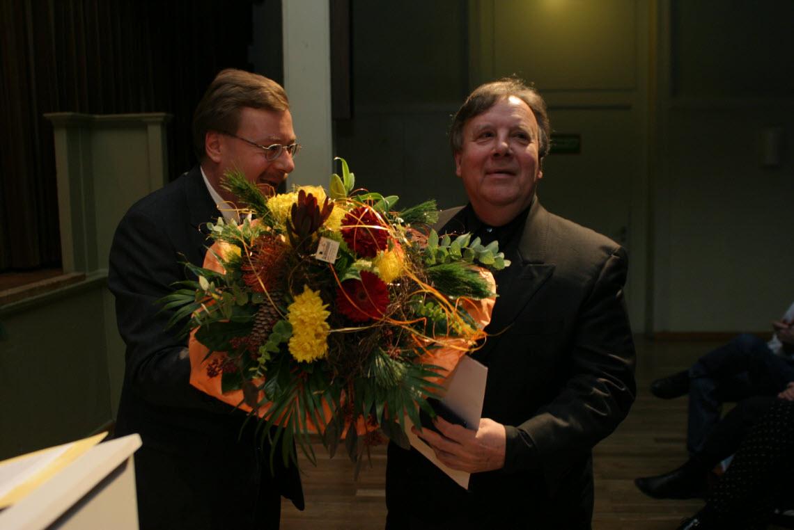 Markus Notter übergibt Heinz Spoerli einen riesigen Blumenstrauss und die goldene Ehrenmedaille