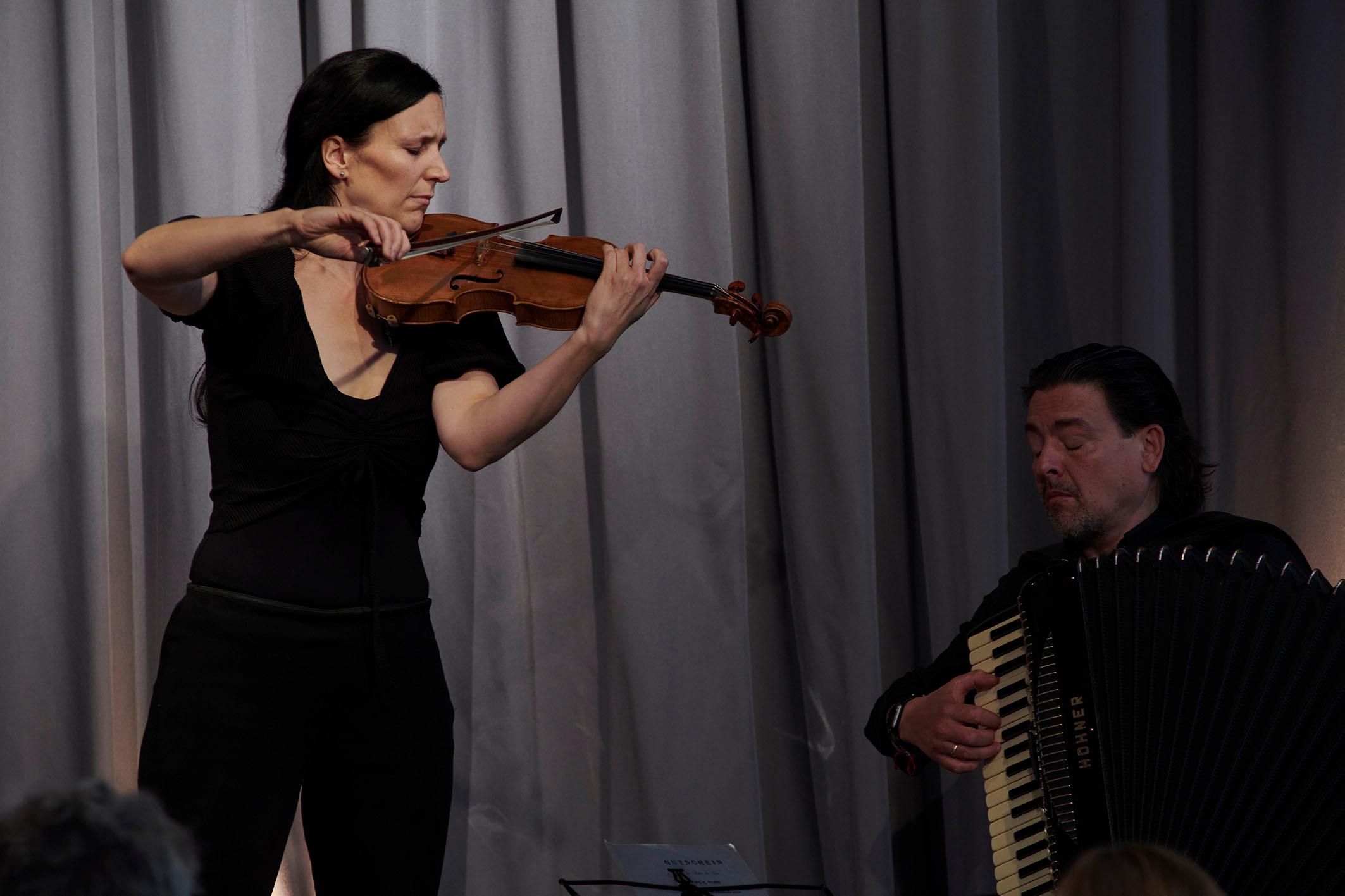Nina Ulli spielt auf der Geige und Goran Kovacevic spielt auf dem Akkordeon klasische Musik