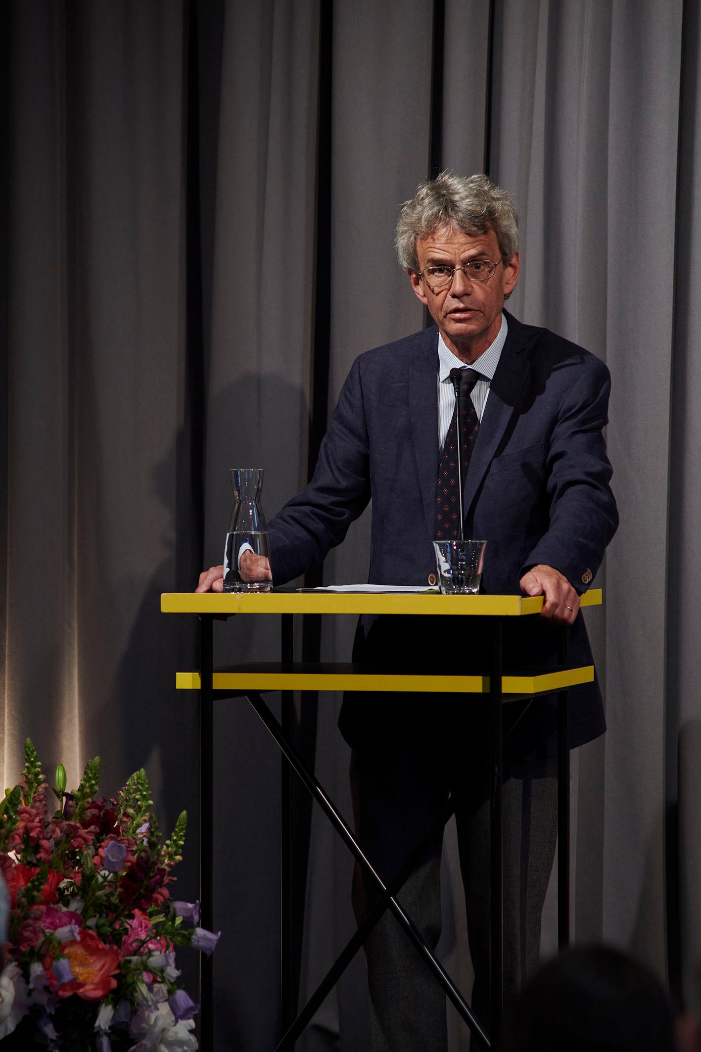 Peter Utz steht am Rednerpult und hält die Laudatio für Beatrice von Matt