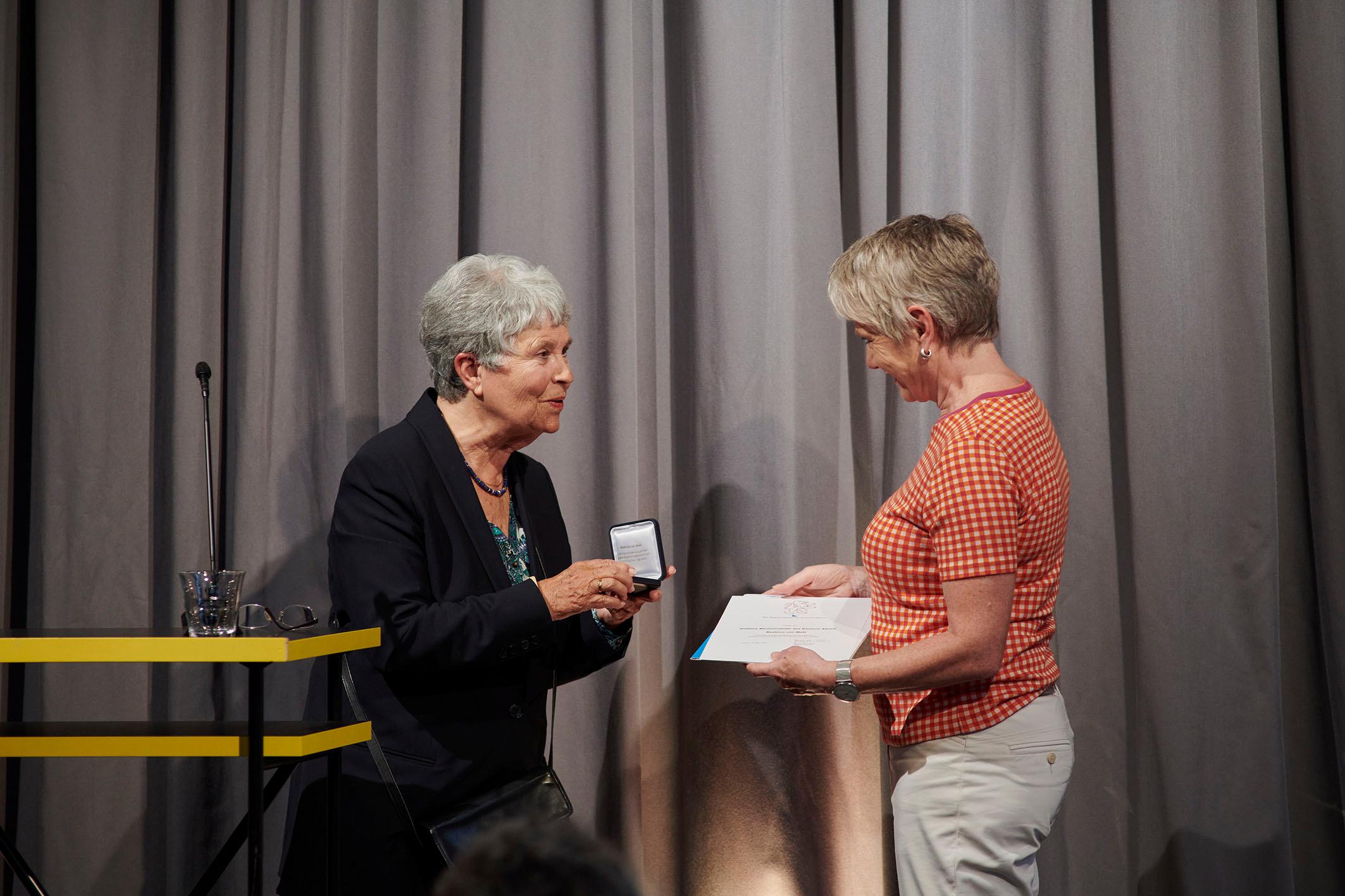 Regierungsrätin Jacqueline Fehr übergibt die goldene Ehrenmedaille und die Urkunde an Beatrice von Matt.