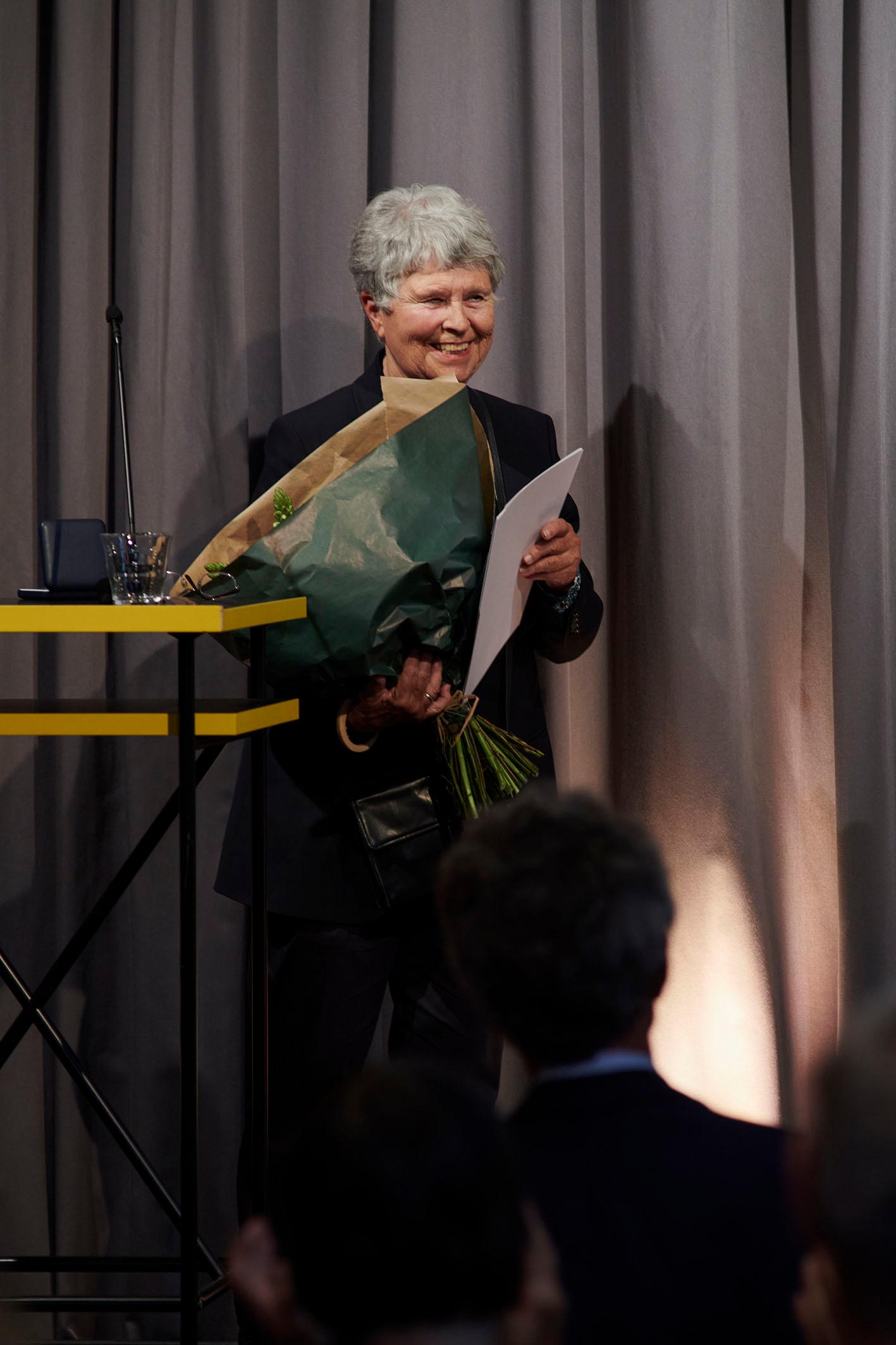 Beatrice von Matt mit Blumenstrauss und strahlendem Lachen.