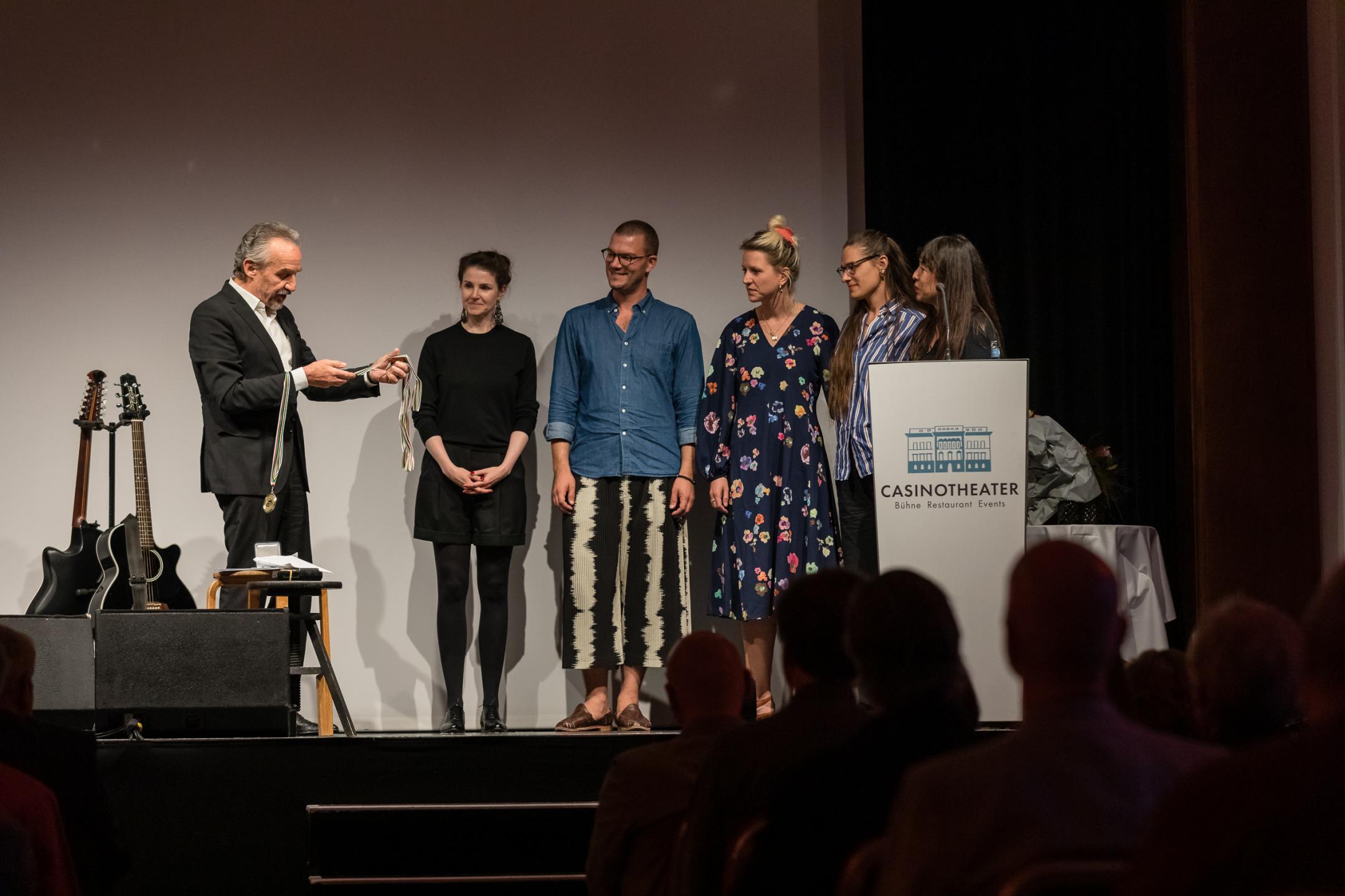 Patrick Frey verteilt Medaillen an seine Mitarbeiter