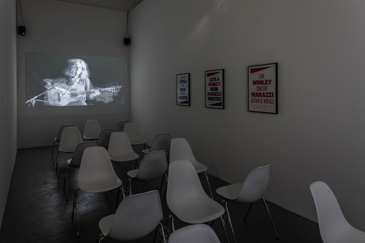Videoinstallation, schmaler Raum, Stühle in verschiedener Richtung