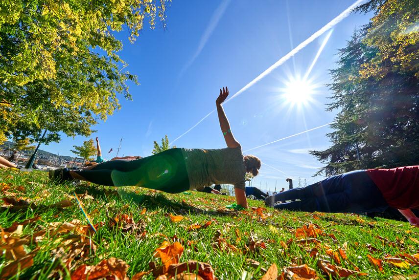 Sportlerinnen und Sportler trainieren auf einer Wiese.