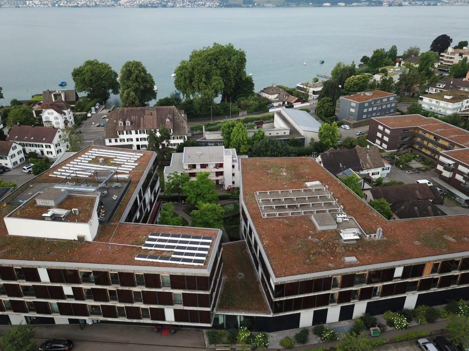 Die Gebäude des Alterszentrum in Stäfa in Seenähe. Sie sind von oben fotografiert , so dass man die  Solarzellen auf dem Dach sieht. 
